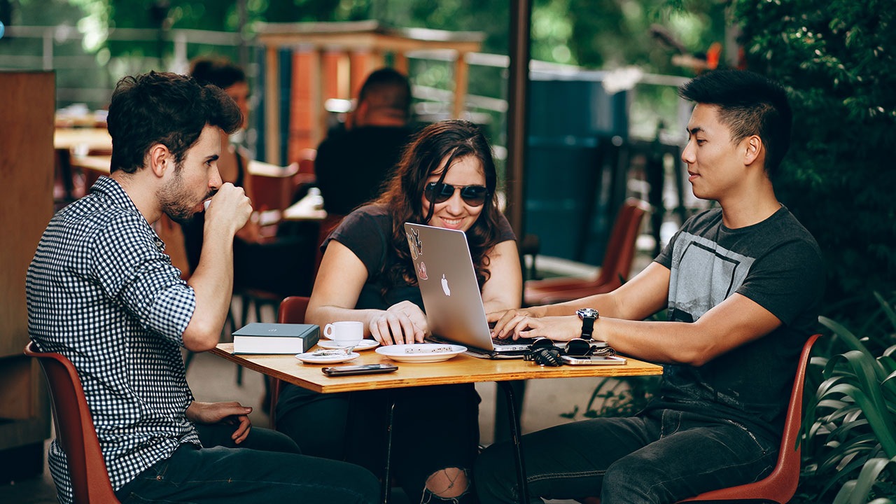 People sitting at a table working on a compute looking to hire remote workers